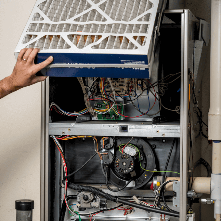 The image shows the back of a furnace and all of it's wires and air filter.